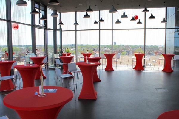 Rote Stehtische vor der Glaskulisse der Skylounge mit Blick auf Bocholt.