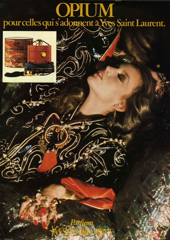 Werbung für Opium mit einem weiblichen Model versunken in Kissen gekleidet in eine schwarze Mandarinjacke mit goldenen Applikationen