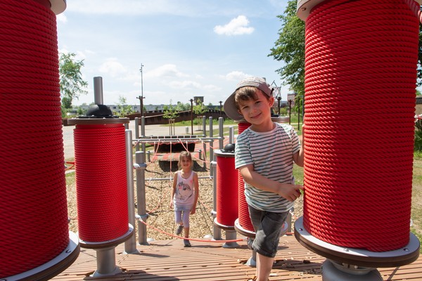 Zwei Kinder laufen über den Spielplatz.