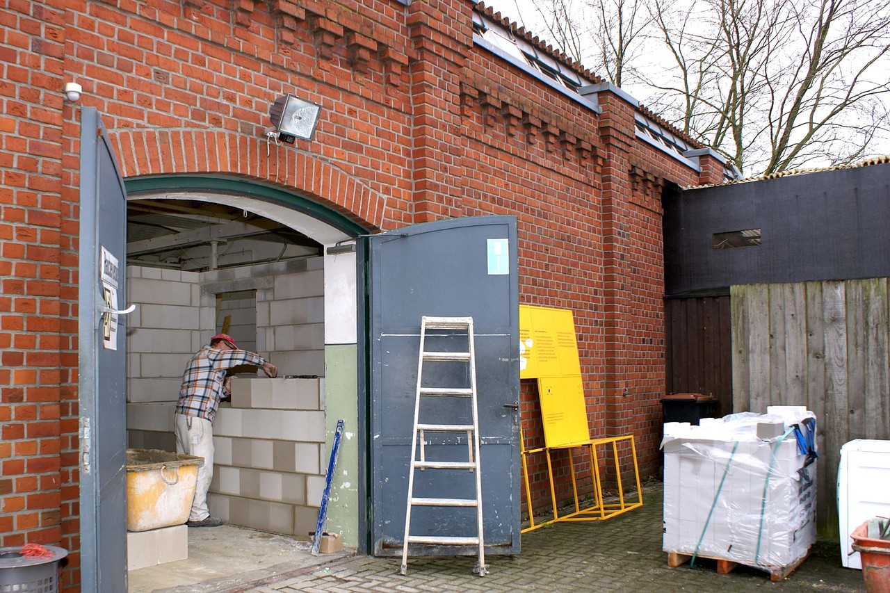 An der Rückseite des Websaals stehen noch alte Container und Schuppen, die als Lager für das Museumsrestaurant dienen (rechts). 