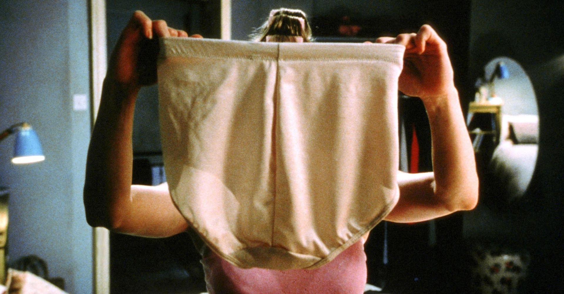 Szene aus dem Film Bridget Jones, in der die Protagonistin eine formende Unterhose vor ihr Gesicht hält