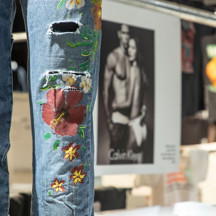 Moderne Jeanshose mit Löchern und Blumenmotiven (vergrößerte Bildansicht wird geöffnet)