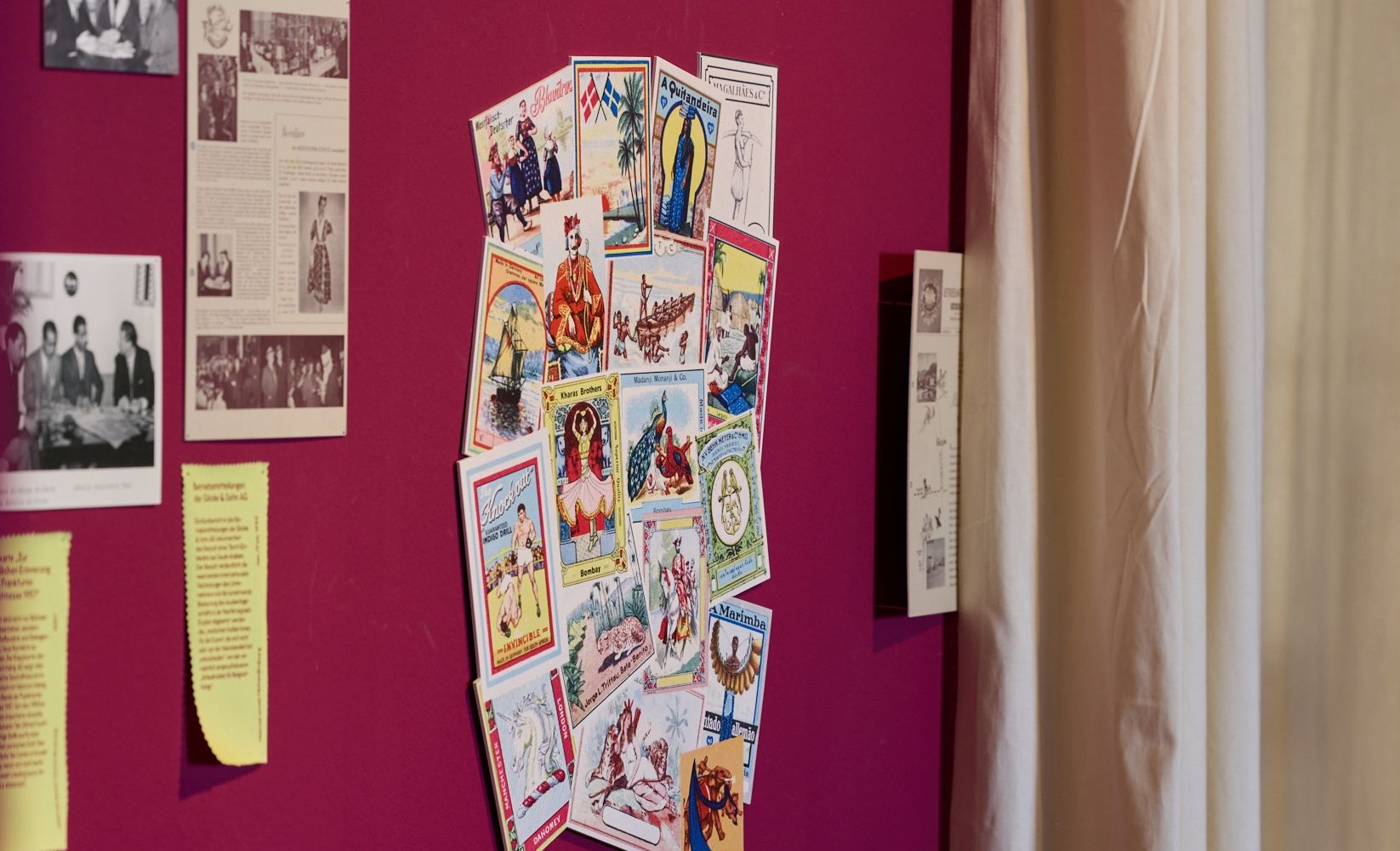 Ausstellungswand mit einer Collage von farbigen Etiketten zur Kennzeichnung von Exportware für afrikanische Länder.