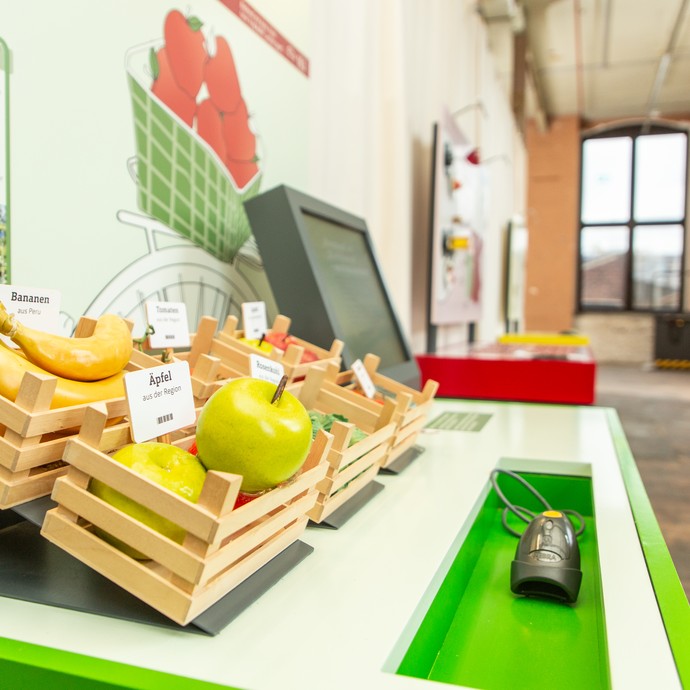 Blick in die Ausstellung: Ausstellungsstation mit Kisten mit Spielzeugobst. (vergrößerte Bildansicht wird geöffnet)